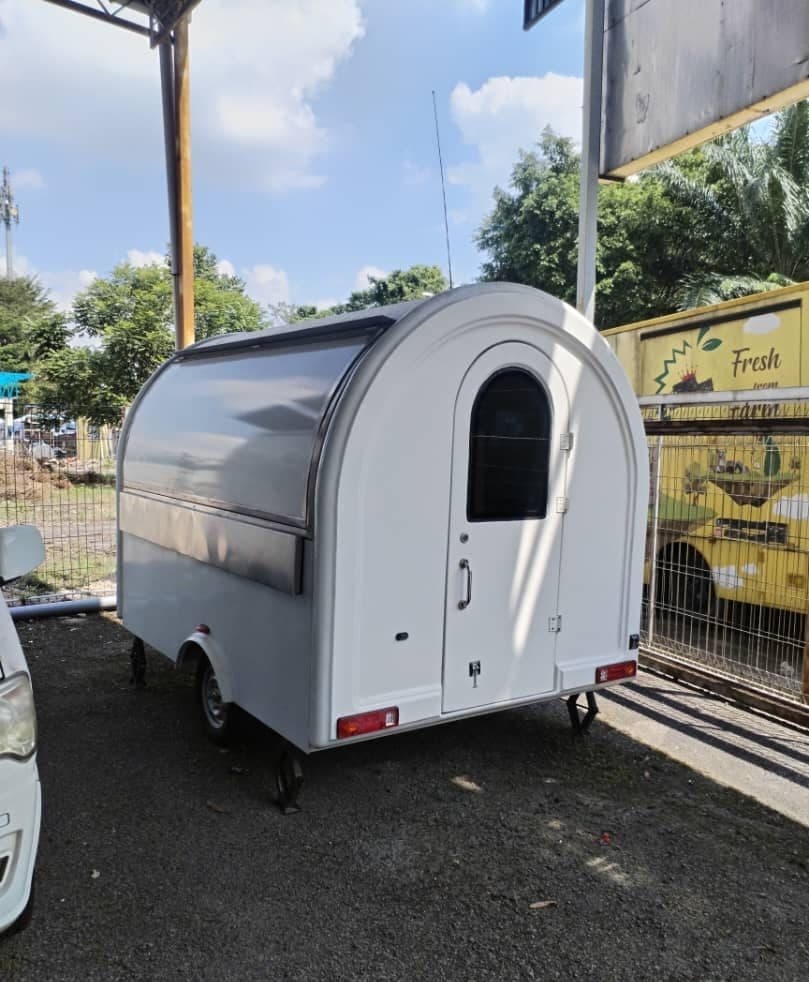 Rounded white food trailer kiosk with a serving window