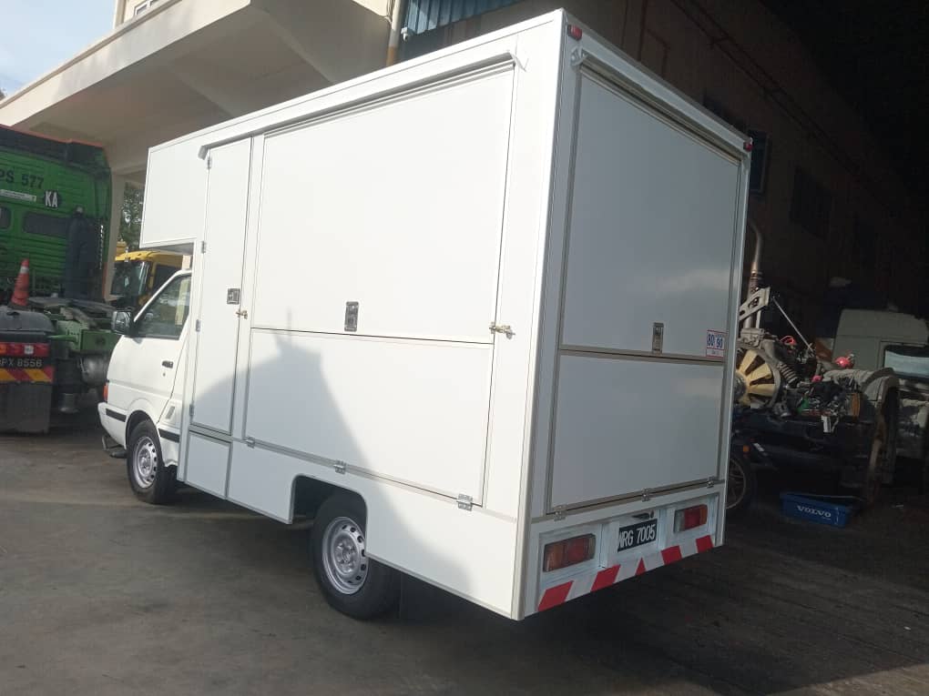 White food box body on a small van, rear three-quarter view