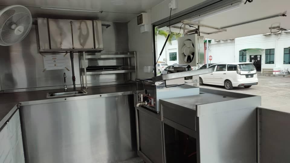 Food truck interior with stainless counters and a wall fan
