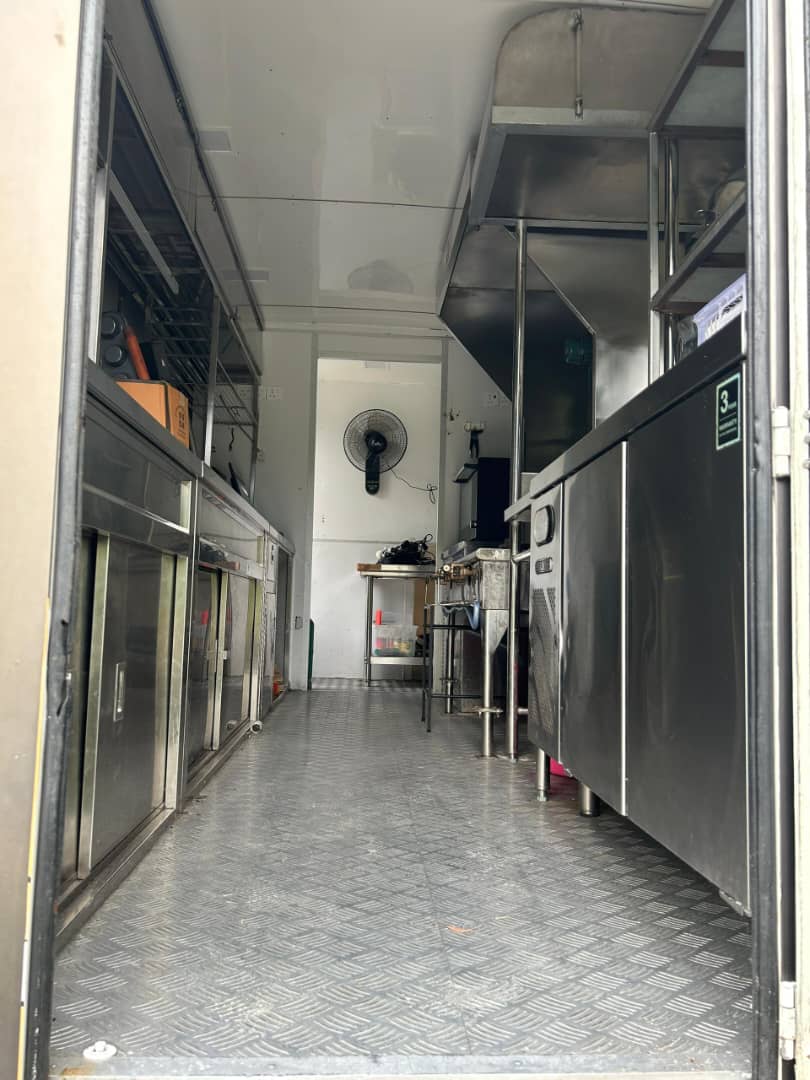 Long food truck interior with stainless cabinets on both sides and a chequer-plate floor