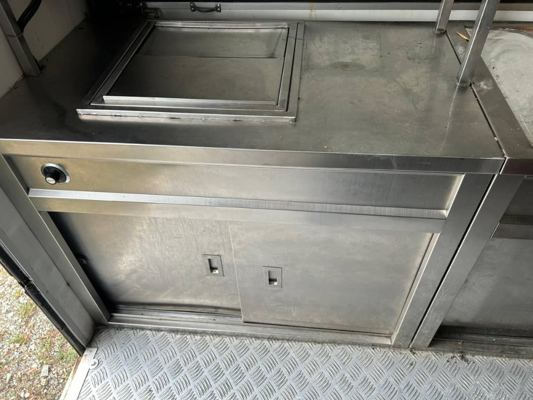 Close-up of stainless steel cabinetwork above a chequer-plate floor